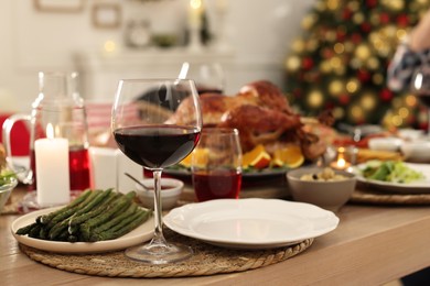 Photo of Festive dinner with delicious food and wine on table indoors, space for text. Christmas celebration