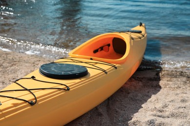 Yellow kayak on beach near river. Summer camp activity