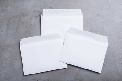 Simple white paper envelopes on grey table, flat lay
