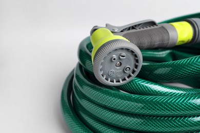 Watering hose with sprinkler on light grey background, closeup. Space for text