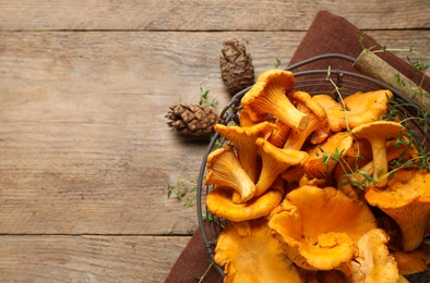Fresh wild chanterelle mushrooms on wooden table, flat lay. Space for text