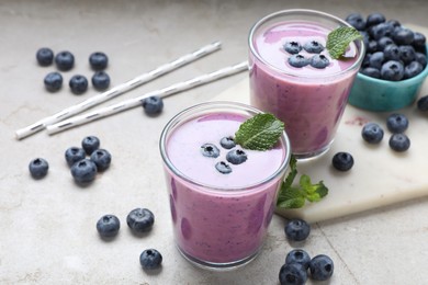 Photo of Freshly made blueberry smoothie on light grey table