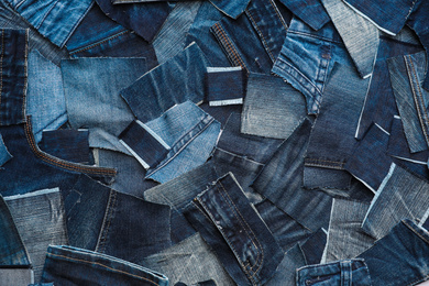 Many patches of old jeans as background, top view