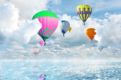 Fantastic dreams. Hot air balloons in sky with fluffy clouds over sea