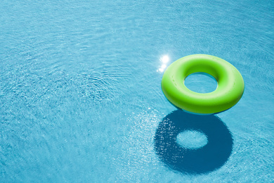 Inflatable ring floating in swimming pool, space for text. Summer vacation