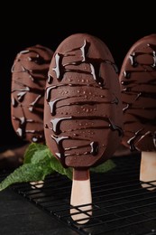 Delicious glazed ice cream bars and mint on black table