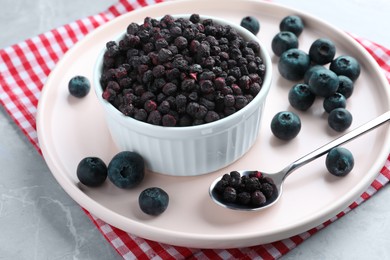 Freeze dried and fresh blueberries on light grey table, closeup