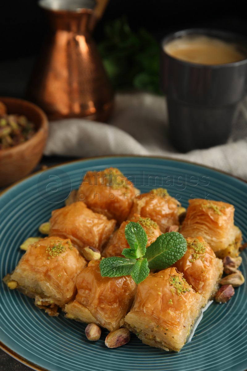 Delicious baklava with pistachio nuts and mint on plate, closeup
