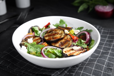 Delicious salad with roasted eggplant, cheese and arugula served on table