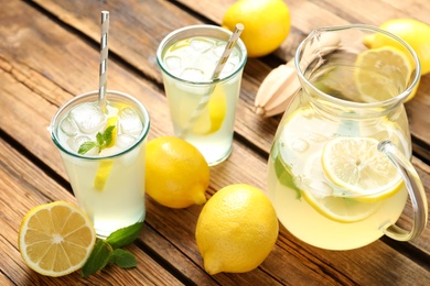 Photo of Natural lemonade with mint on wooden table. Summer refreshing drink