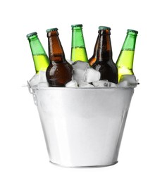 Photo of Metal bucket with different bottles of beer and ice cubes on white background