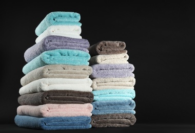 Different fresh soft terry towels on dark background
