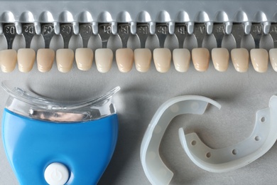Teeth whitener, mouth covers and shade guide on grey background, top view