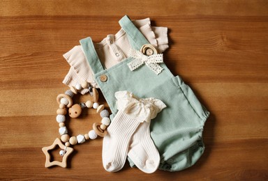 Children's clothes and toy on wooden table, flat lay