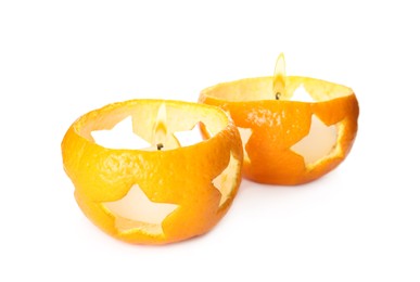 Photo of Candles in tangerine peels as holders on white background