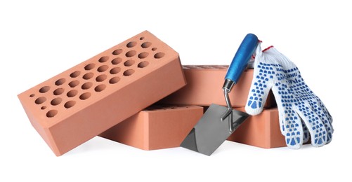 Photo of Pile of red bricks, trowel and gloves on white background