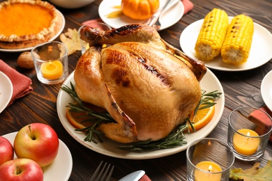 Traditional Thanksgiving day feast with delicious cooked turkey and other seasonal dishes served on wooden table