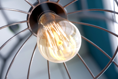 Image of Stylish metallic pendant lamp with Edison light bulb indoors, closeup