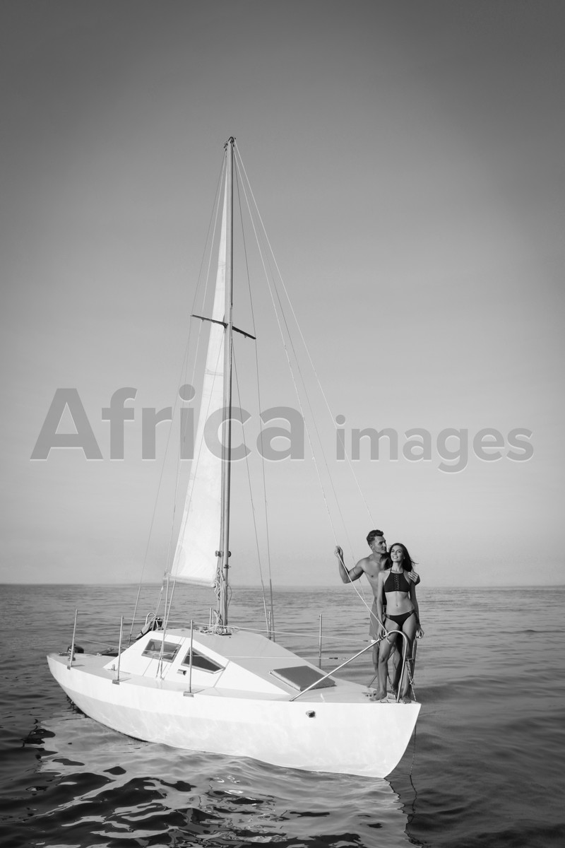 Young man and his beautiful girlfriend in bikini on yacht. Black and white tone