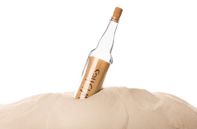 Corked glass bottle with Wishes note in sand on white background