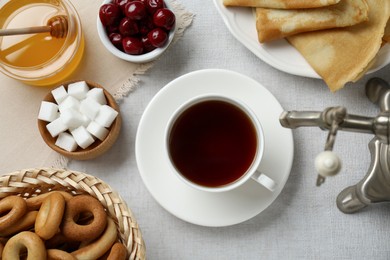 Photo of Cup of aromatic tea and treats on table, flat lay