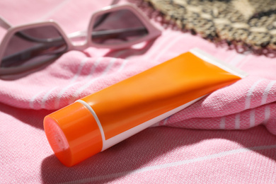 Photo of Tube of sun protection cream on towel, closeup