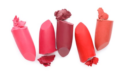 Different beautiful lipsticks on white background, top view