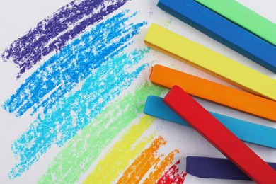 Colorful pastel chalks and scribbles on white background, flat lay. Drawing materials