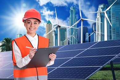 Industrial engineer in uniform and view of solar panels and wind energy turbines installed outdoors