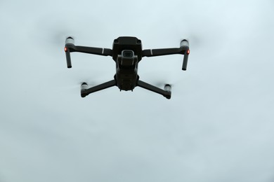 Modern drone against cloudy sky, low angle view
