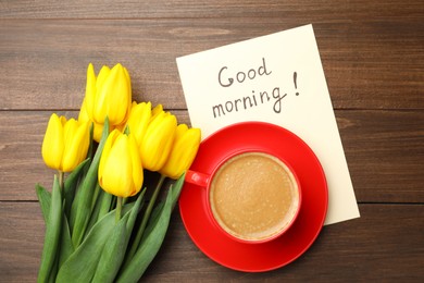 Beautiful yellow tulips, cup of aromatic coffee and Good Morning note on wooden table, flat lay