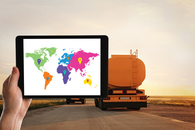 Logistics concept. Woman using tablet with world map on screen against truck