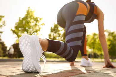 Woman in fitness clothes ready for running outdoors, low angle view