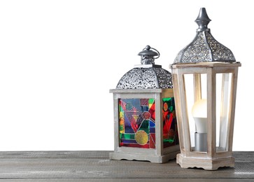Decorative Arabic lanterns on wooden table against white background
