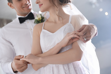 Photo of Happy newlywed couple dancing together in festive hall, closeup
