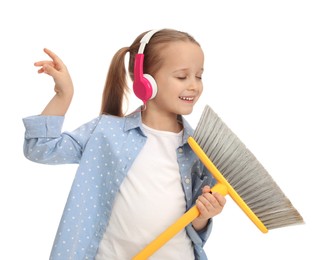 Cute little girl in headphones with broom singing on white background
