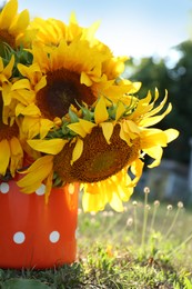 Photo of Bouquet of beautiful sunflowers in tin outdoors