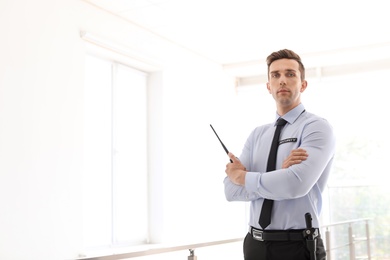 Male security guard with portable radio transmitter indoors