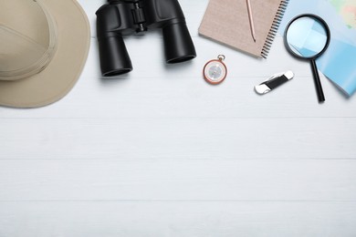 Flat lay composition with different safari accessories on white wooden background, space for text