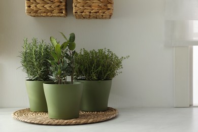 Different aromatic potted herbs on countertop in kitchen