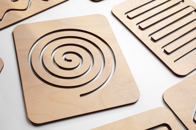 Photo of Wooden finger labyrinths on white background. Montessori toy
