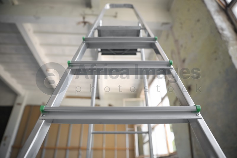 Photo of Metal ladder in old empty building, low angle view