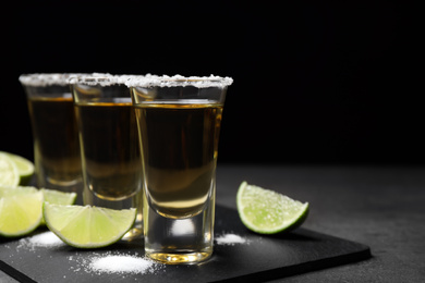 Mexican Tequila shots with salt and lime on grey table. Space for text