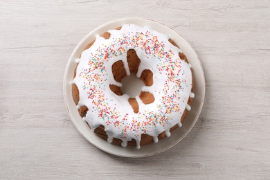Glazed Easter cake with sprinkles on white wooden table, top view