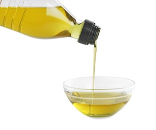 Photo of Pouring cooking oil from bottle into bowl on white background, closeup