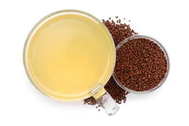 Photo of Cup of aromatic buckwheat tea and granules on white background, top view