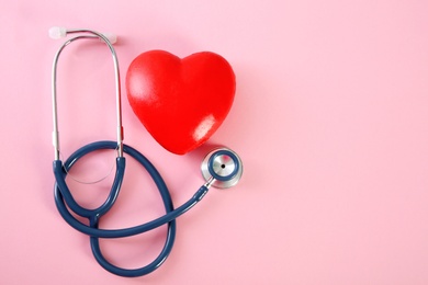 Flat lay composition with red heart model and stethoscope on color background, top view