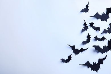 Many black paper bats on white background, flat lay with space for text. Halloween decor