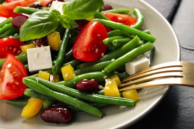 Tasty salad with green beans served on black table, closeup