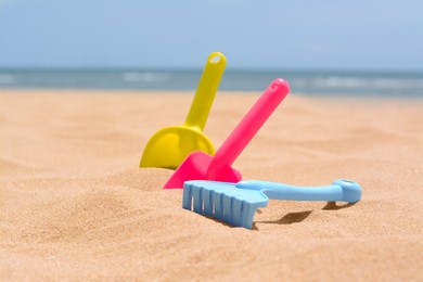 Set of colorful beach toys on sand near sea